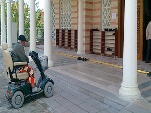 Akülü arabasıyla cami kapısında saf tutuyor