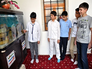 Camide bulunan akvaryumda çocuklar balık besliyor
