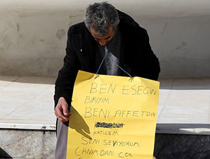 Eşiyle barışmak için oturma eylemi yaptı