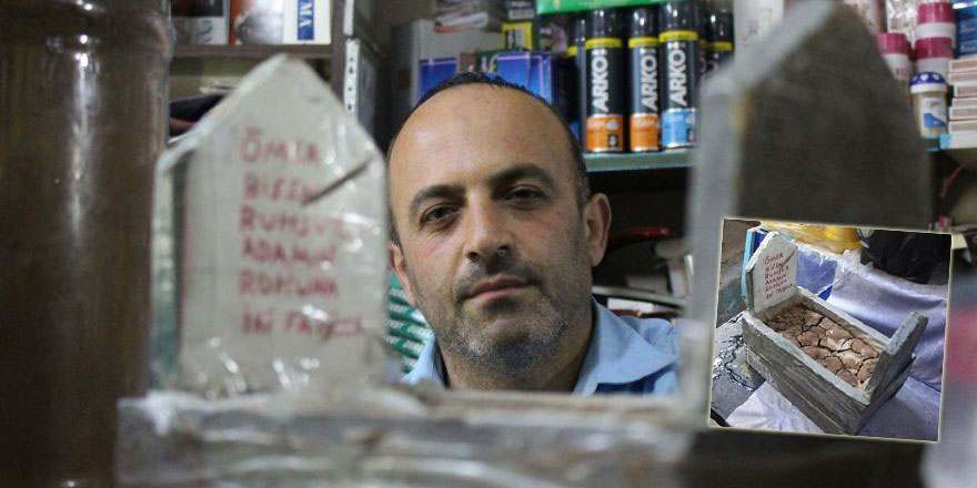 Ölümü hatırlatmak için bakkal dükkanında maket mezar sergiliyor