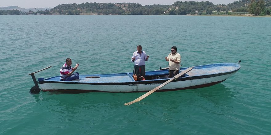 Ölmüşlerine dua etmek için sandalla suyun ortasına geliyorlar