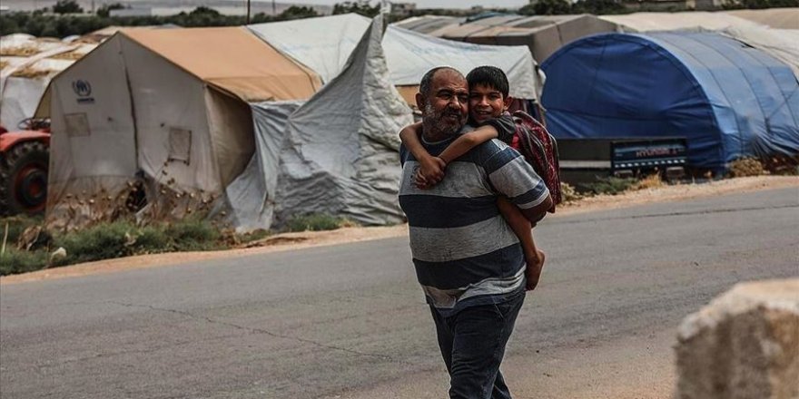 Suriyeli baba engelli oğlunu sırtında taşıyarak okula götürüyor