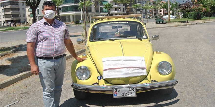 Arabasına maske takarak Kovid-19 tedbirlerine dikkat çekti