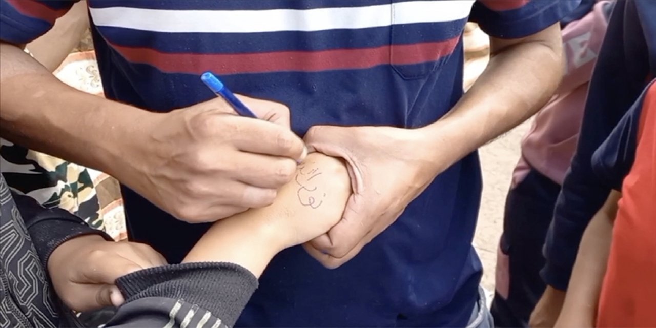 Terörist israil saldırılarında vurulan çocukları bulmak için ellerine adları yazılıyor