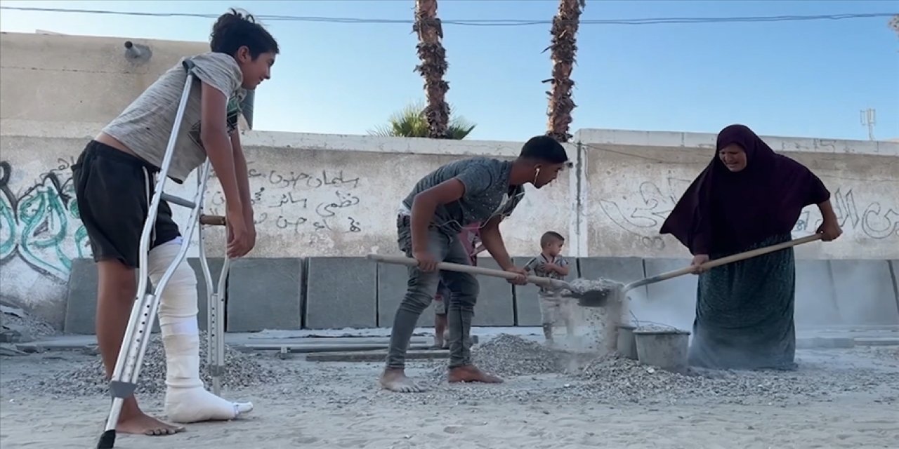 Gazzeli kadın, israil saldırılarında ölenler için yıkılan evlerin molozlarından mezar hazırlıyor